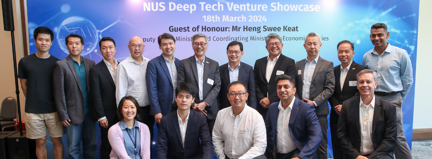 Group of people posing in front of "NUS Deep Tech Venture Showcase" backdrop.